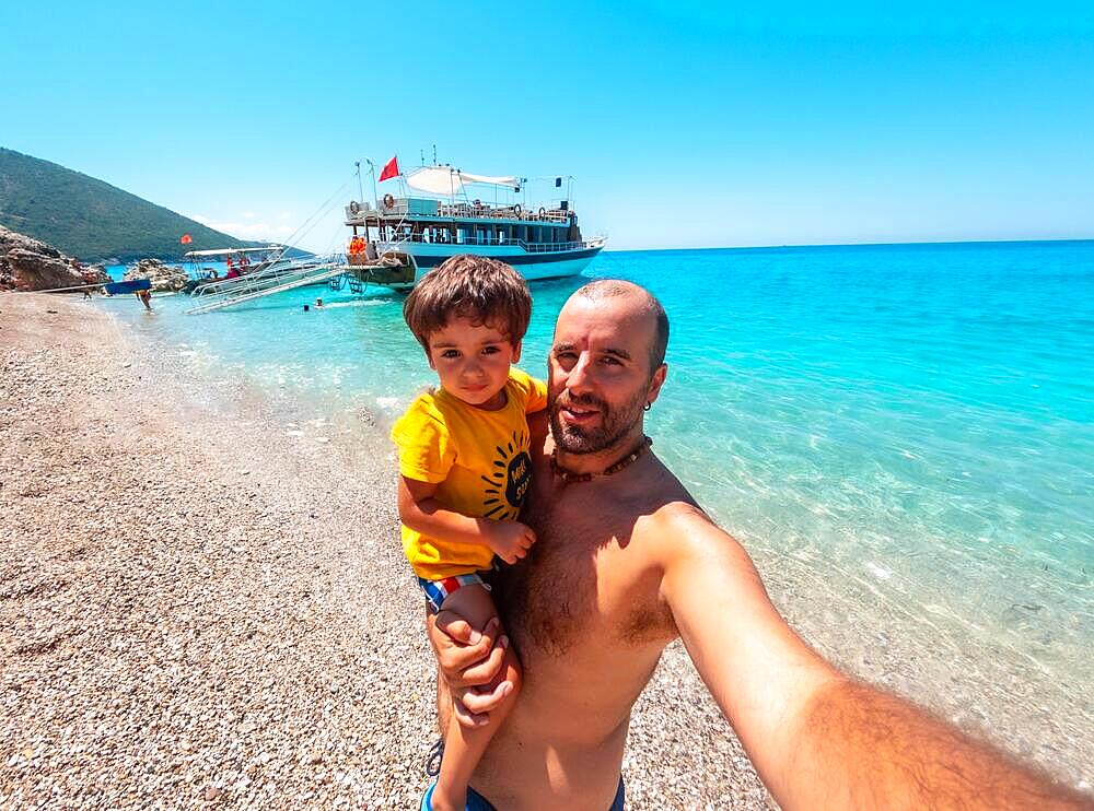 Father and son on the paradise beach of Kroreza or Krorez seen from the boat on the Albanian riviera in Sarande, Albania, Europe