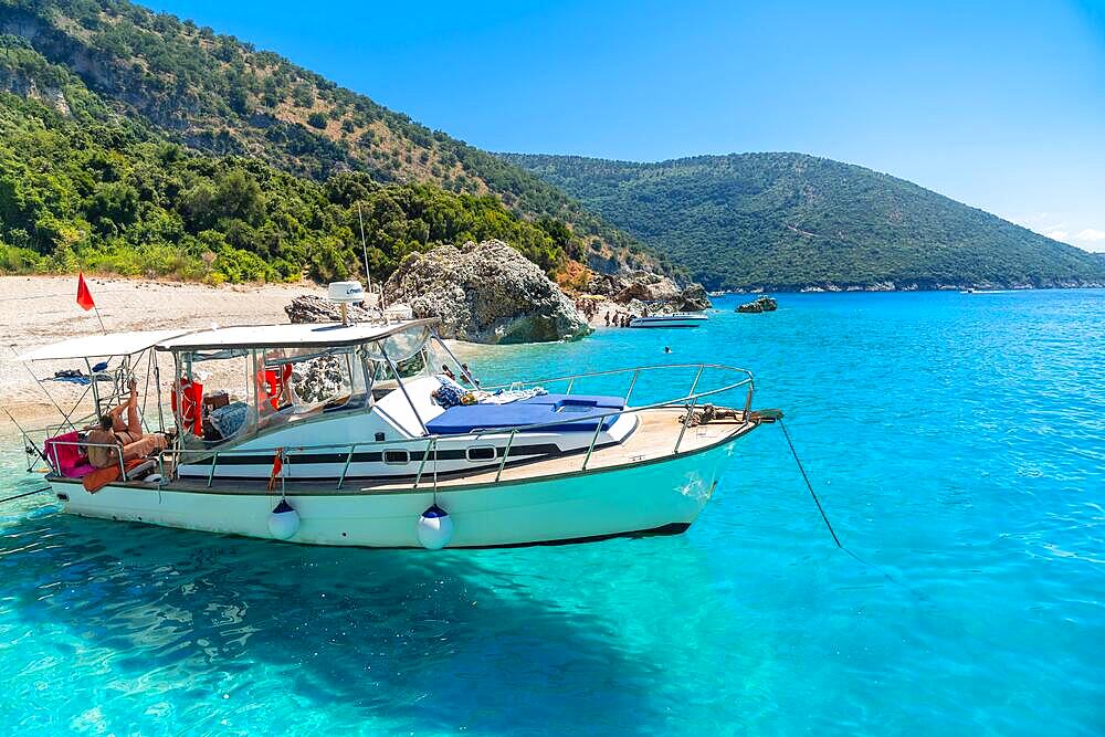 Boat in the transparent waters of the paradise beach of Kroreza or Krorez from the boat on the Albanian riviera in Sarande, Albania, Europe