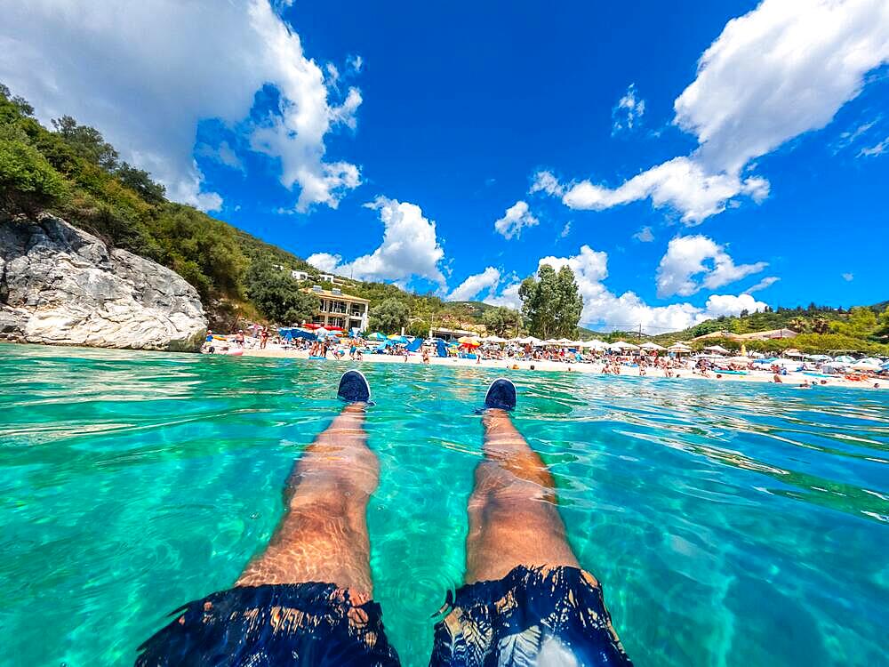 A man resting in the sea on the beach in summer of Paralia Mikros Gialos in the south of the island of Lefkada. Greece