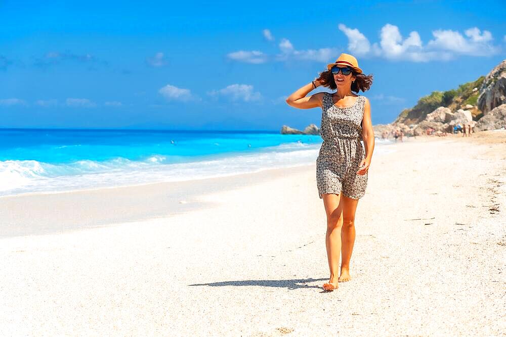 Portrait of woman with hat on Megali Petra beach with turquoise water of Lefkada island, Ionian Sea, Greece, Europe