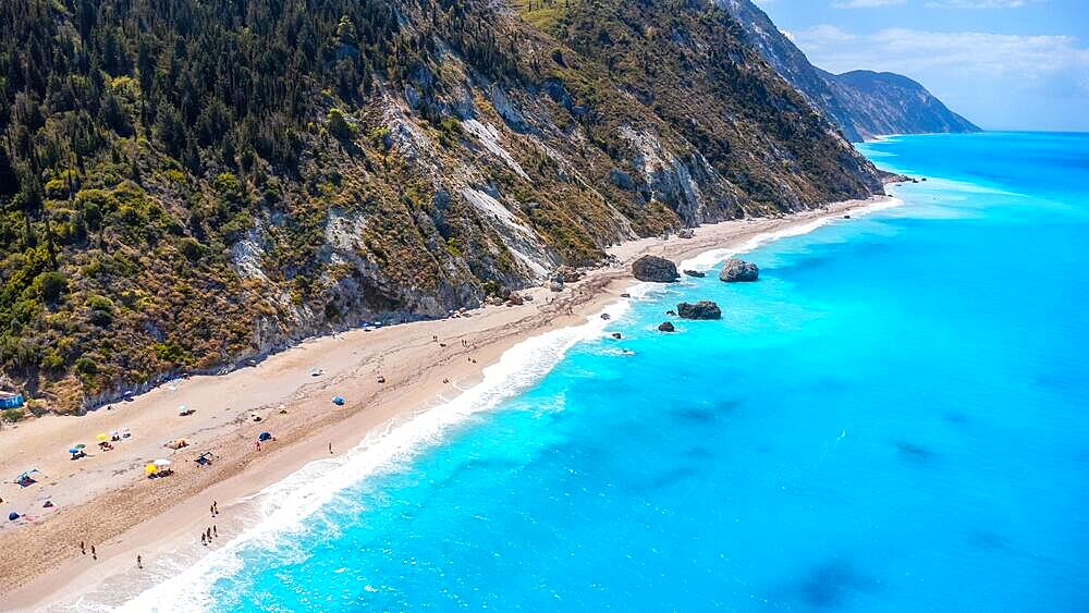 Drone shot of beautiful crystal clear turquoise and blue water at Megali Petra sandy beach in Lefkada. Greece