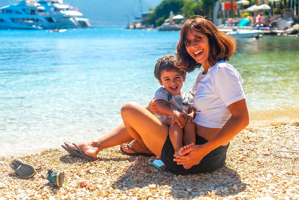 Mother son playing beach summer on a Fiskardo beach in Kefalonia island, Greece, Europe