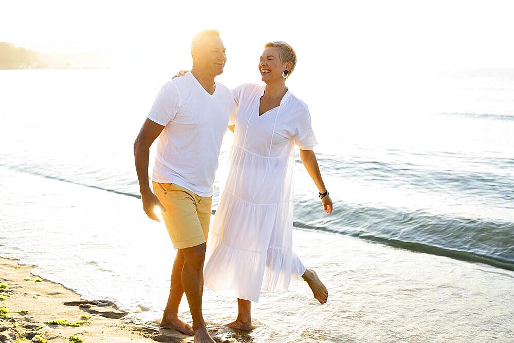 Full shot couple having fun seaside