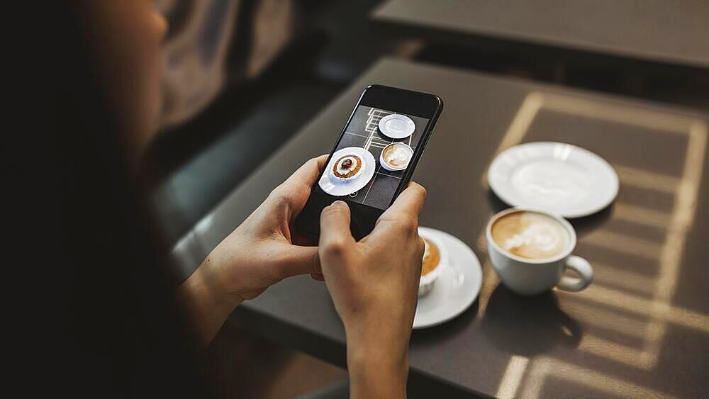 Young woman taking picture her coffee