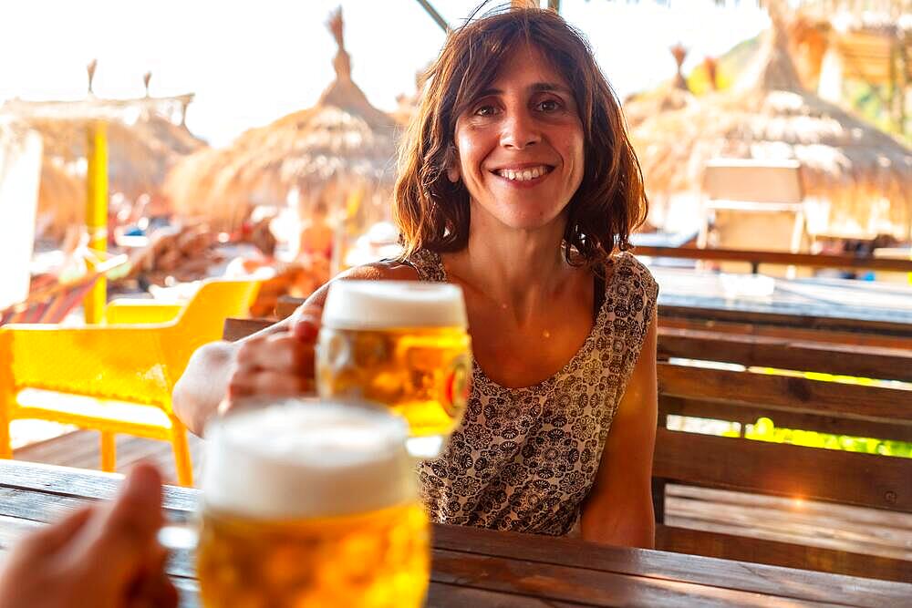 Toast of a couple on the beach in summer drinking a few beers on summer vacation