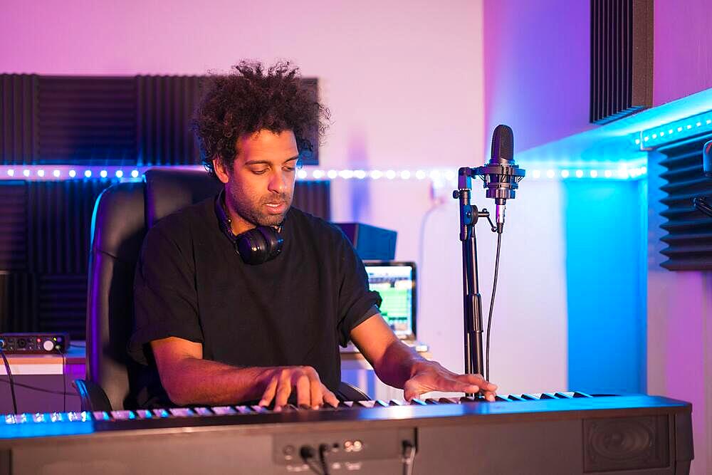 Frontal view of a musician playing the piano in a production studio