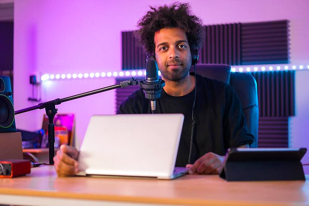 Portrait of a vlogger in a music studio with electronic tools to broadcasting