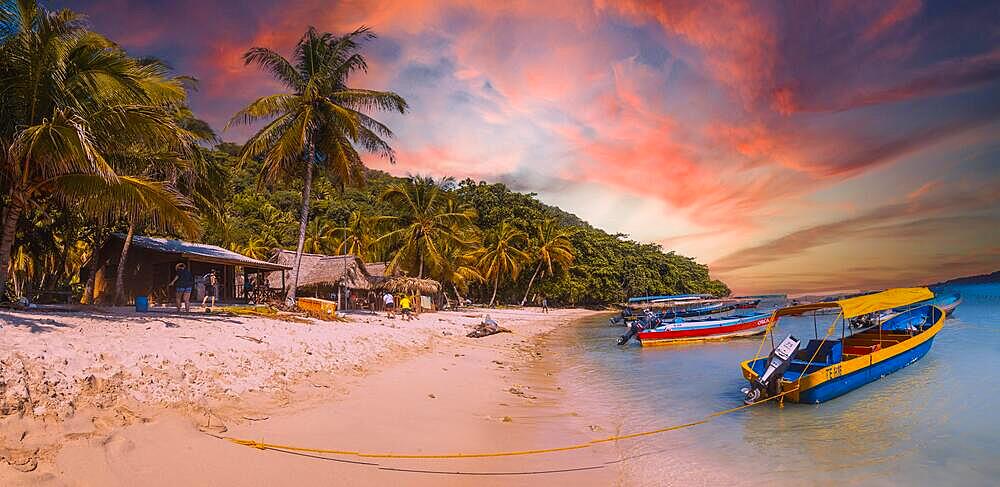 Tela, Honduras, January 2020: Local transport boats at Cocalito beach in Punta de Sal on the Caribbean Sea at sunset, Tela, Central America