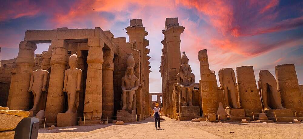 Sculptures of ancient Egyptian pharaohs and drawings on the columns of the Luxor Temple in the evening. Egypt