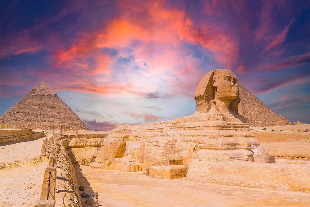 The Great Sphinx of Giza and in the background the Pyramids of Giza at sunset, the oldest funerary monument in the world. In the city of Cairo, Egypt, Africa