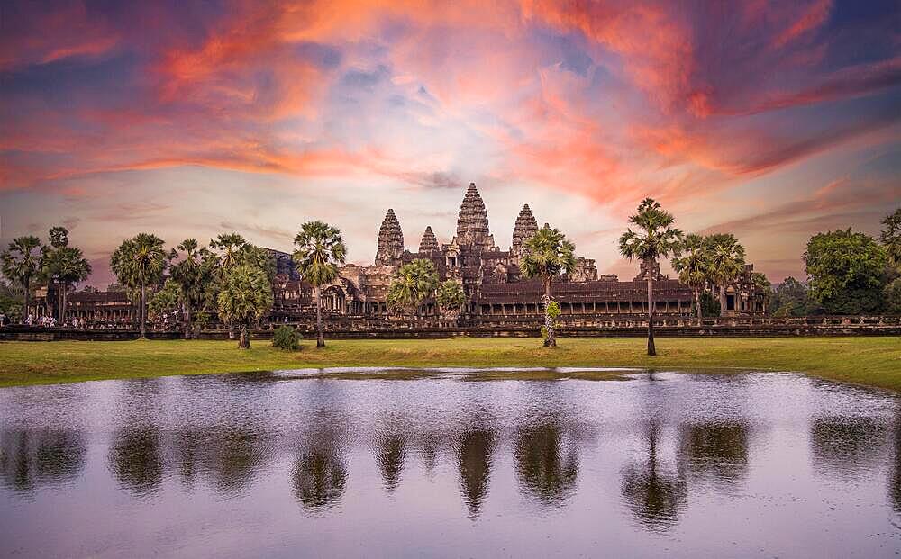 Angkor Wat main temple reflected in the water in a beautiful summer sunrise. Cambodia