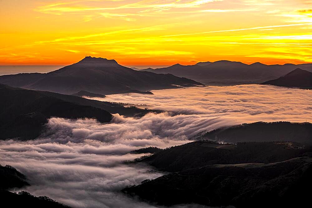 Detail of the beautiful Mount Larrun on a winter morning by the sea of clouds at the golden hour of dawn. Basque Country