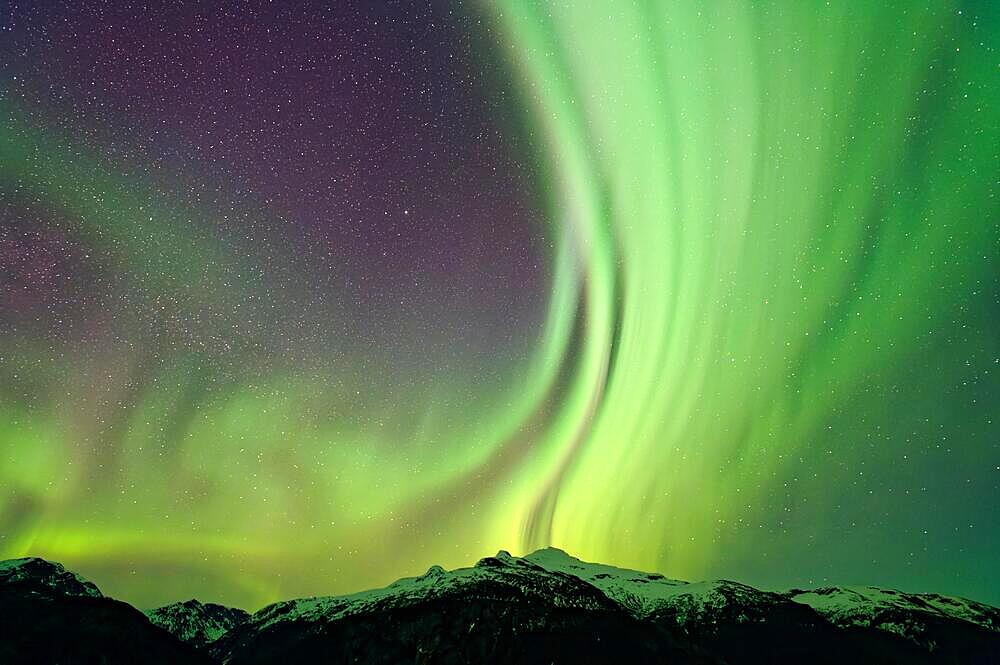 Northern lights (Aurora borealis) in different colours, starry sky, snowy mountain landscape in front, Alaska, USA, North America