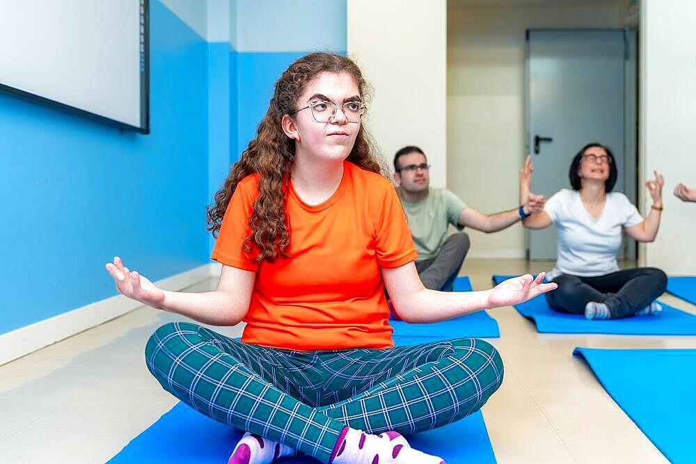 Focus on a disabled woman in lotus position during yoga class next to friends