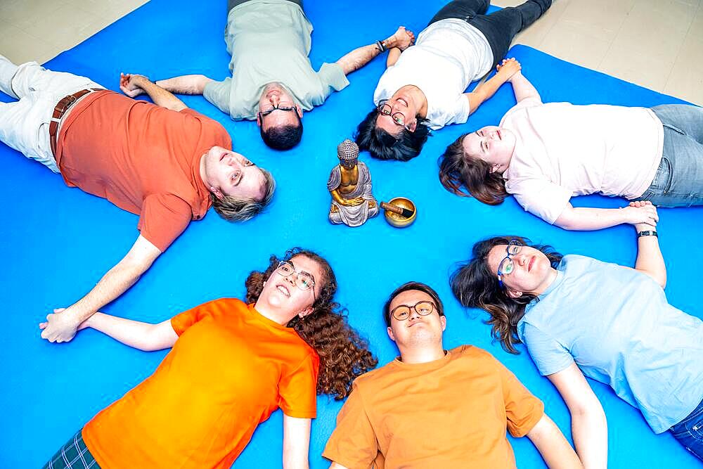 Disabled people lying on the mat during breathing exercises to relax on a gym