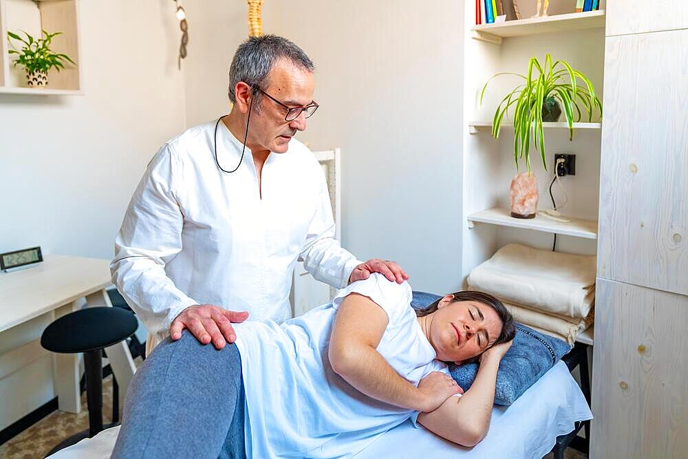 Relaxed woman receiving a massage from a Qi gong expertise in a clinic