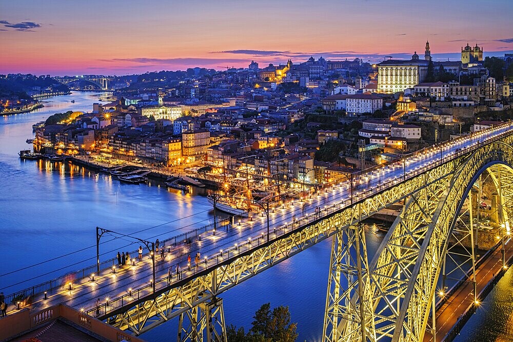 View of illuminated Porto city and Douro river and Dom Luis bridge I from famous tourist viewpoint Miradouro da Serra do Pilar in evening twilight. Porto, Vila Nova de Gaia, Portugal, Europe