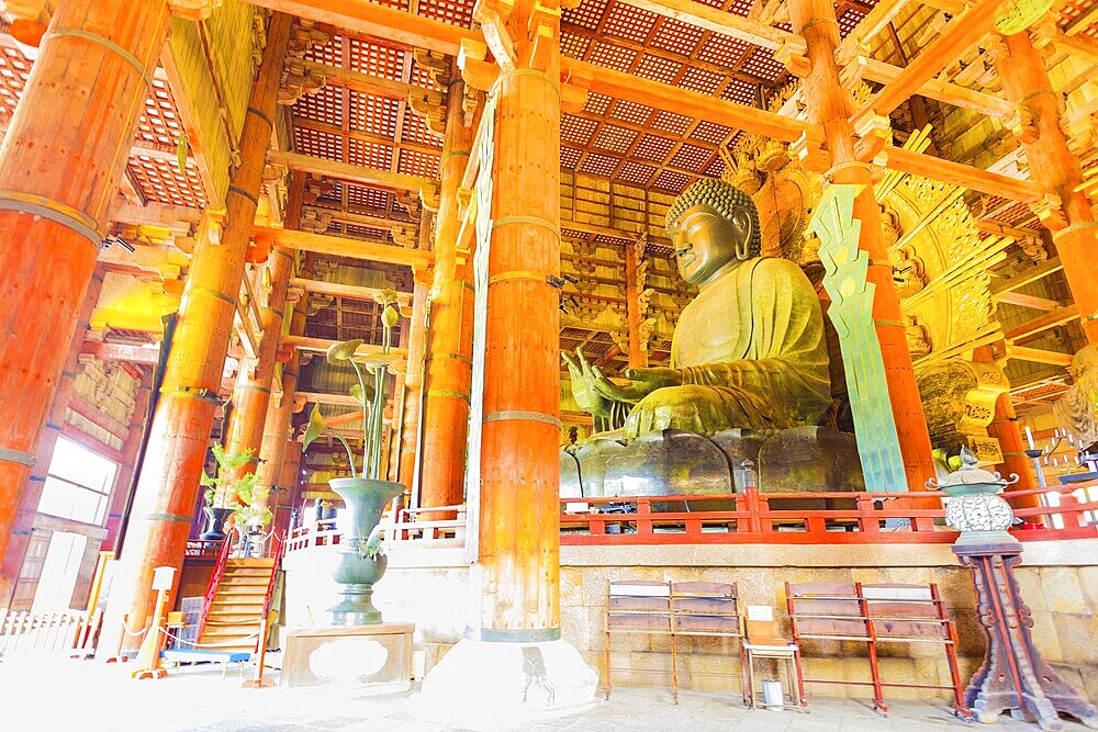 Side profile of Daibutsu bronze Buddha and ceiling of inside the Great Buddha Hall, Daibutsuden at Todai-ji temple in Nara, Japan. Horizontal interior