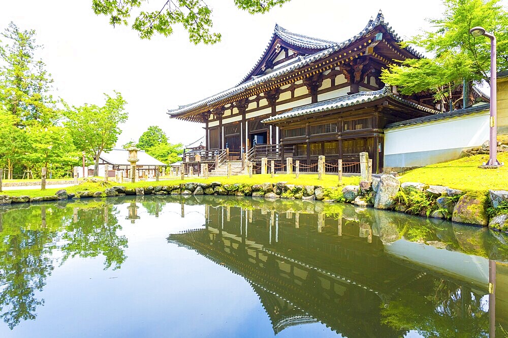 Front entrance of Sangatsu-do Hall reflected in the front pond on a sunny morning in the Todai-ji temple complex at Nara, Japan. Horizontal