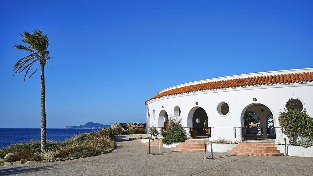 A white, round building with round windows and arches by the sea, next to it stands a palm tree, thermal springs, thermal baths, thermal baths of Kallithea, Kallithea, Rhodes, Dodecanese, Greek Islands, Greece, Europe