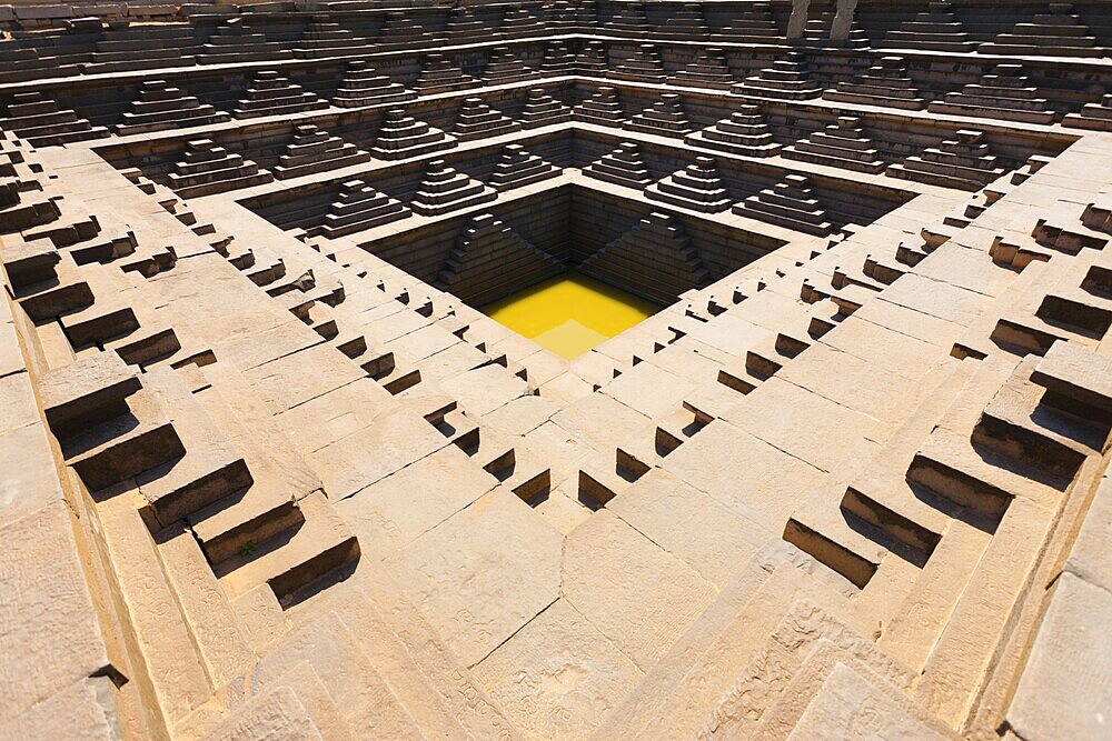 A now empty reservoir or tank was used in ancient times for storing water in Hampi, Karnataka, India. horizontal