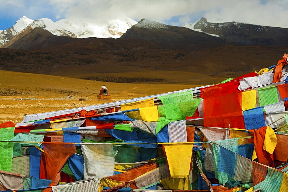 A beautiful natural mountain landscape behind a traditional Tibetan oven and a mass of prayer flags in Tibet, China, Asia