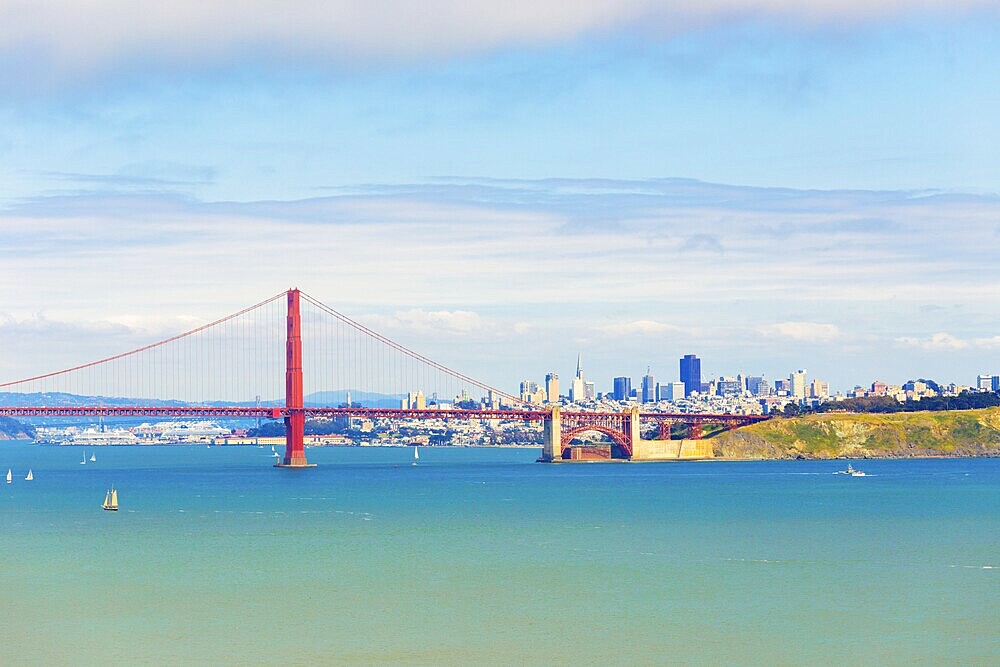 Distant telephoto landscape view over ocean water through Golden Gate Bridge to San Francisco Cityscape under a beautiful sunny, blue sky. Copy space