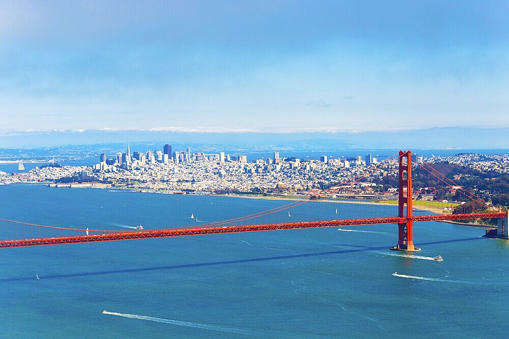 High angle, mid-air, aerial view of downtown San Francisco city, bay seen together with Golden Gate Bridge on a summer, blue sky day in California, compressed using telephoto lens