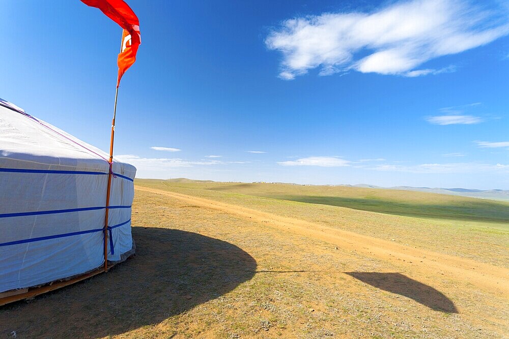 Side of a yurt house opens up to a vast open rural grassland in the countryside of Mongolia