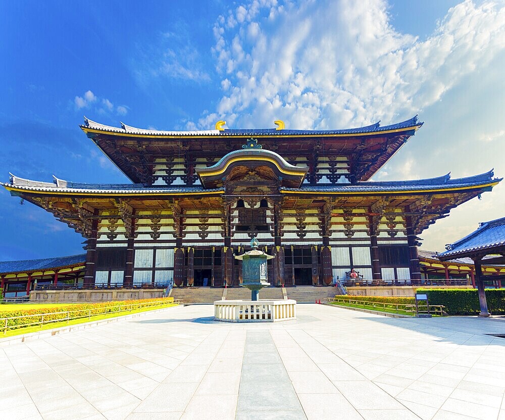 Wide path leading to front exterior facade of Great Buddha Hall, Daibutsuden on sunny, blue sky day in Todai-ji temple empty of people in Nara, Japan. Horizontal