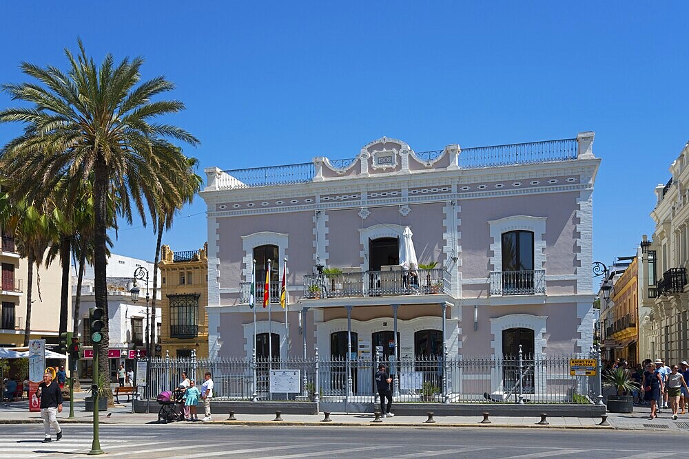 Large historical building with palm trees in front of it, people at a crossroads, Ayuntamentio, town hall, Sanlúcar de Barrameda, Sanlucar, Cádiz, Cadiz, Andalusia, Spain, Europe