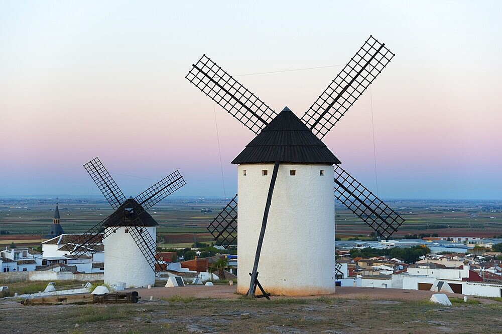 Windmills in a village at sunrise with pink sky, Campo de Criptana, Ciudad Real province, Castilla-La Mancha, Don Quixote Route, Spain, Europe