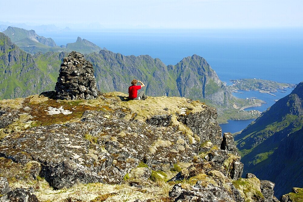MR mountaineer enjoys the view from the summit of mountain Mannen Moskenesoya Lofoten Norway