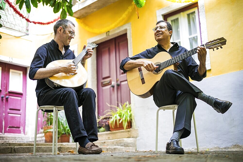 Two fado guitarists with acoustic and portuguese guitars in Alfama, Lisbon, Portugal, Europe