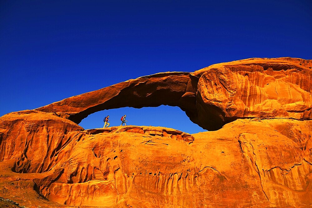 Couple hiking at Rock-Arch Al Kharza, Wadi Rum, Jordan, Middle East, Asia