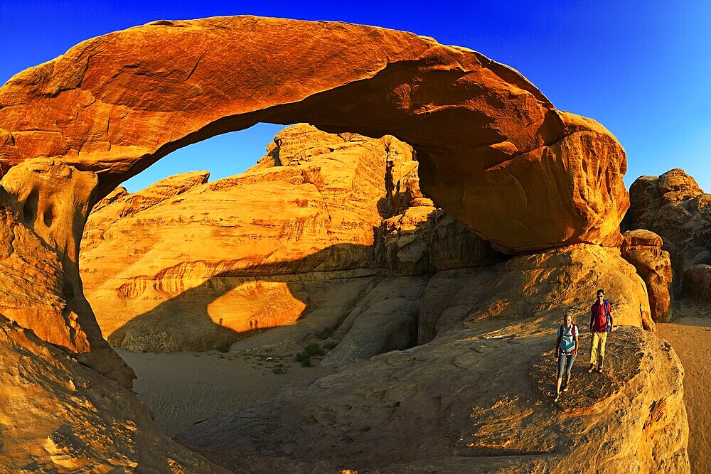 Couple hiking at Rock-Arch Al Kharza, Wadi Rum, Jordan, Asia