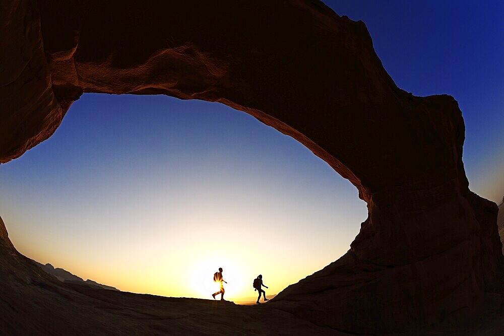 Couple hiking at Rock-Arch Al Kharza, Wadi Rum, Jordan, Asia