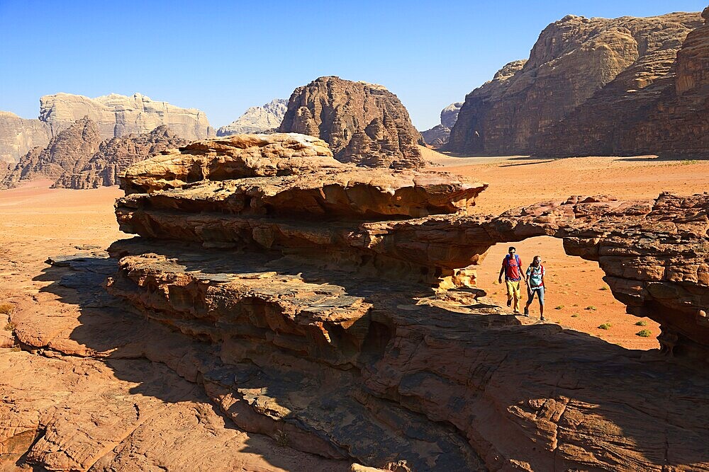 Couple hiking at Rock Arch, Al Borg Alsagheer, Wadi Rum, Jordan, Asia