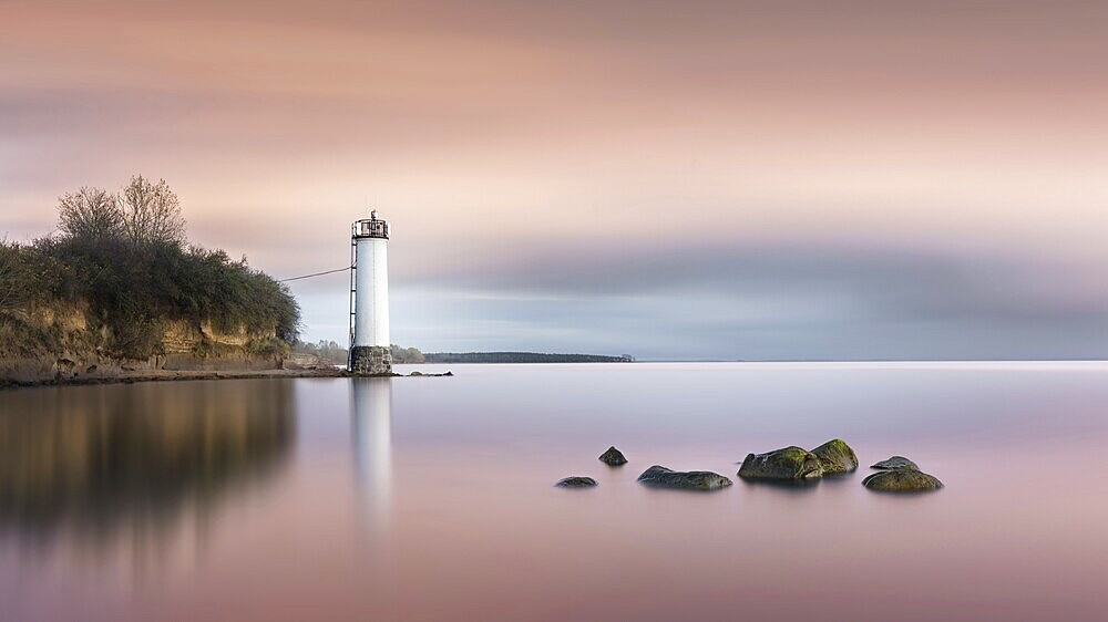 Long exposure of a colourful sunset behind the abandoned lighthouse on the Baltic Sea coast in Maltzien on Rügen, Germany, Europe