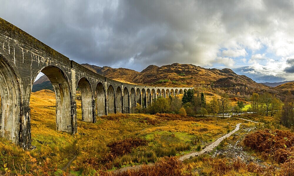 Glenfinnan railway viaduct, with autumn colours and cloudy sky, Glenfinnan, West Highlands, Scotland, Great Britain