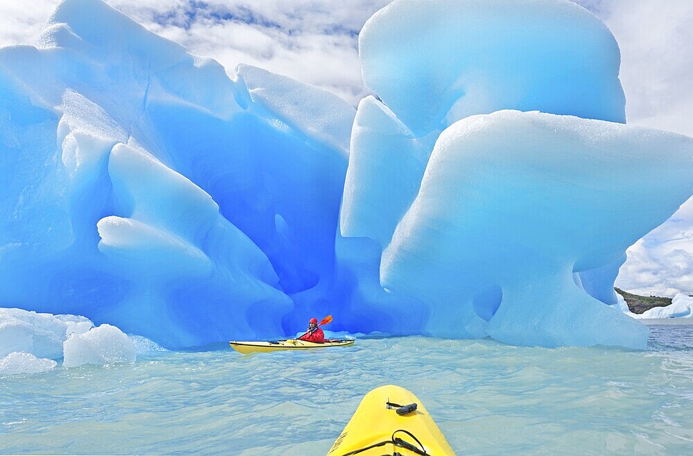 Kayaker heading for icebergs on lake, Lago Grey, Torres del Paine National Park, Patagonian Andes, Patagonia, Chile, South America