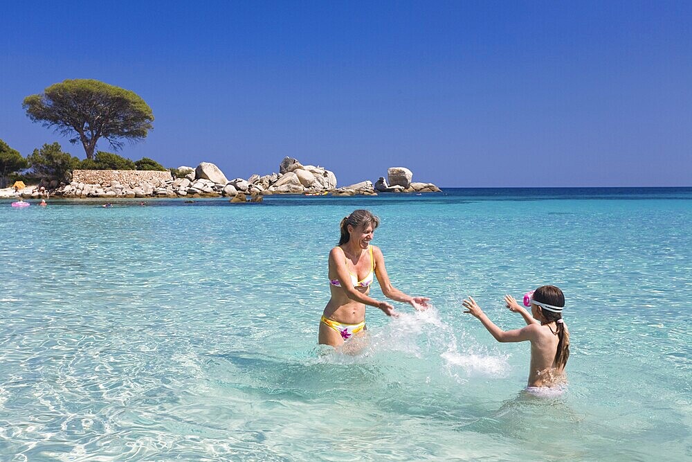 Mother and daughter bathing at Palombaggia beach, south-east coast, Corsica, France, Europe