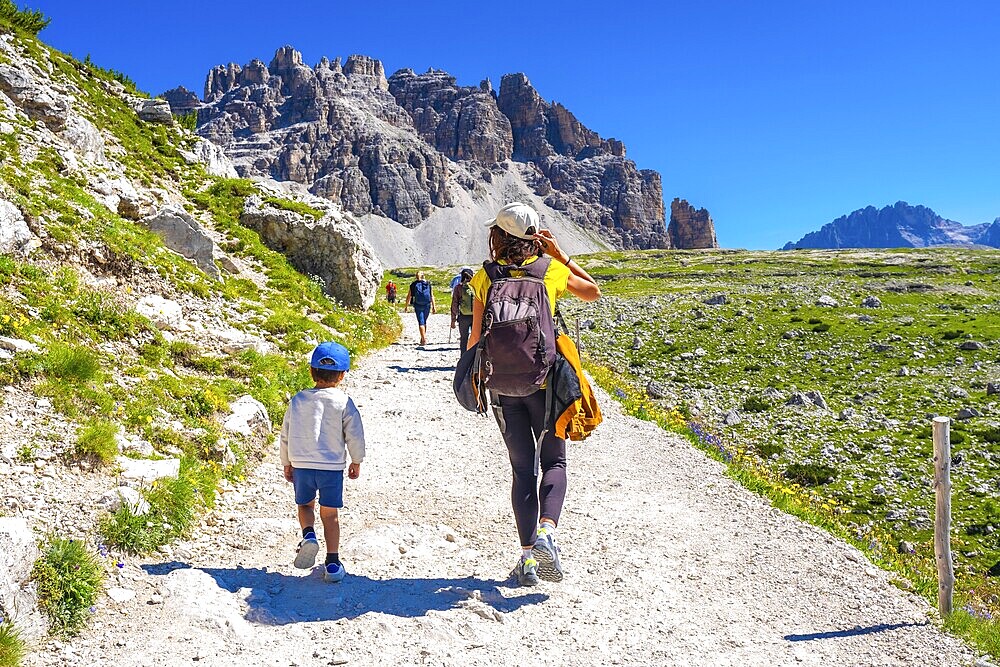 Tourists walking on a sunny summer day on the trail around tre cime di lavaredo in the dolomites