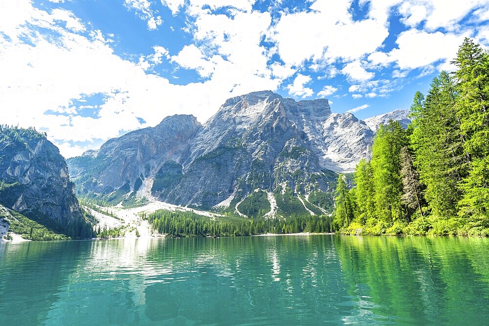Emerald waters reflecting the majestic dolomites peaks at lake braies, a stunning natural wonder in the heart of the italian alps