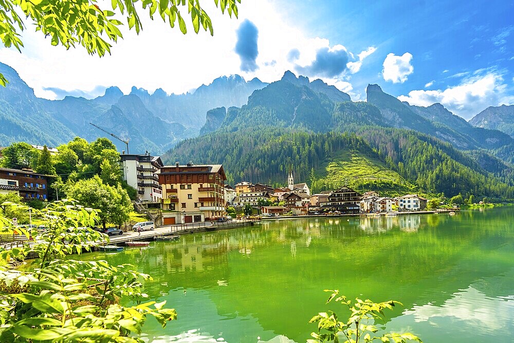 Stunning summer view of alleghe village reflecting on the emerald waters of lake alleghe, surrounded by the majestic dolomites