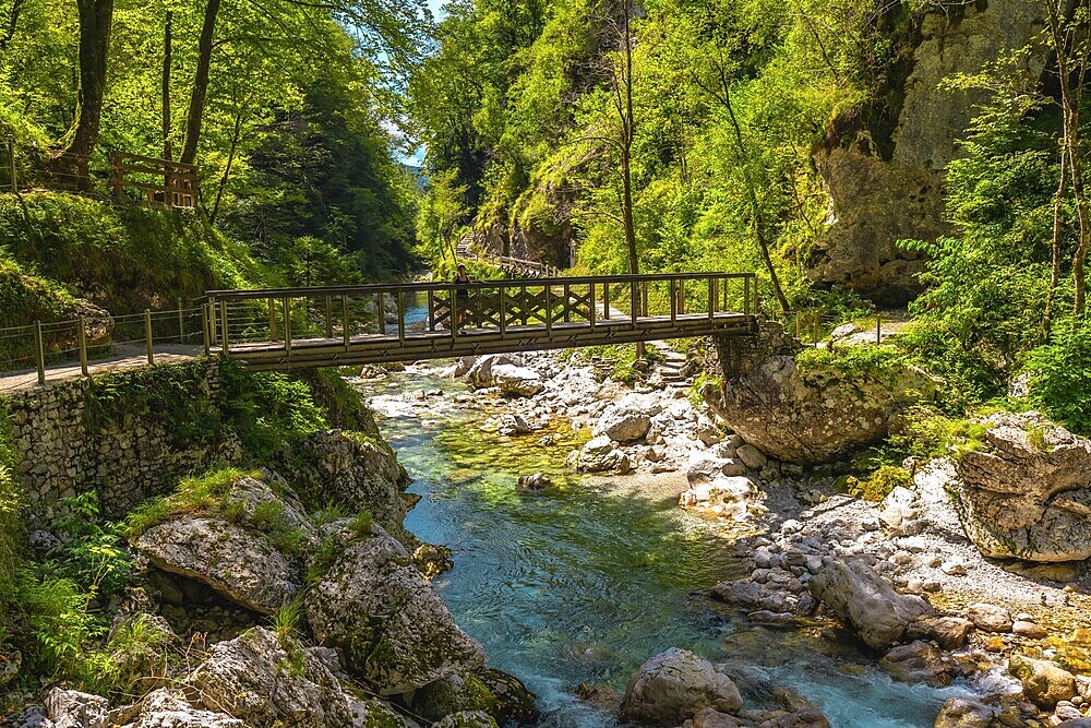 Turquoise water flowing under wooden bridge over tolmin gorges in triglav national park, slovenia