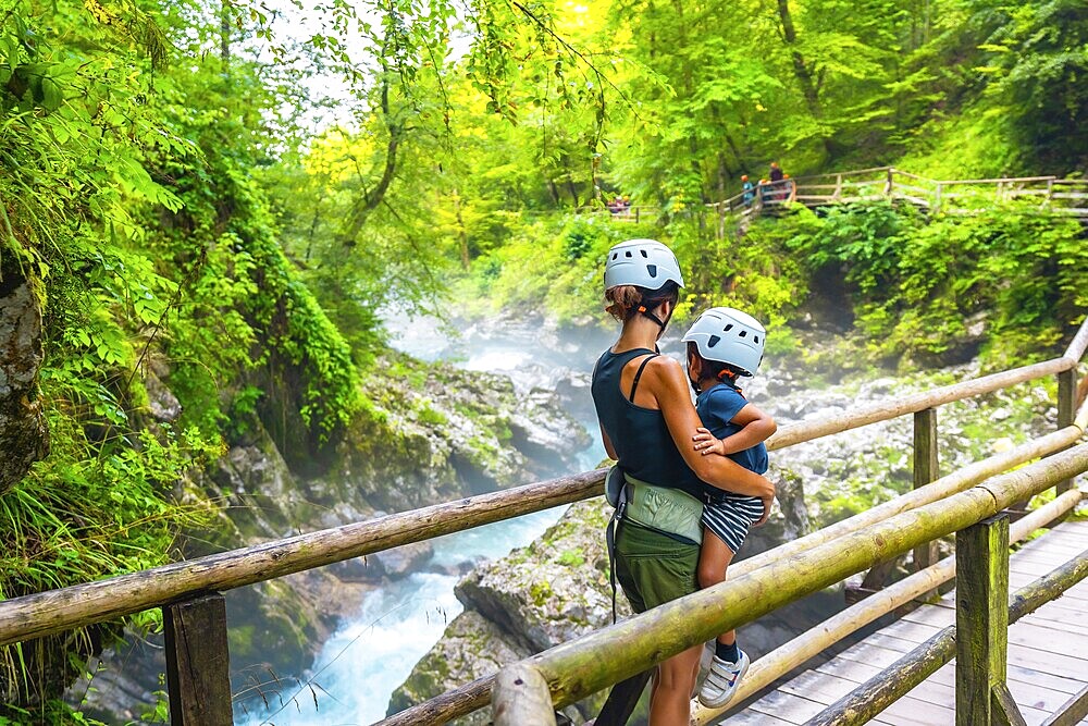 Mother holding her child while admiring the stunning vintgar gorge near bled, slovenia, during summer
