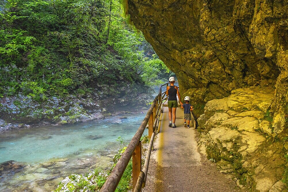 Tourists walking along the radovna river in vintgar gorge, near bled, slovenia, enjoying the stunning scenery and peaceful surroundings