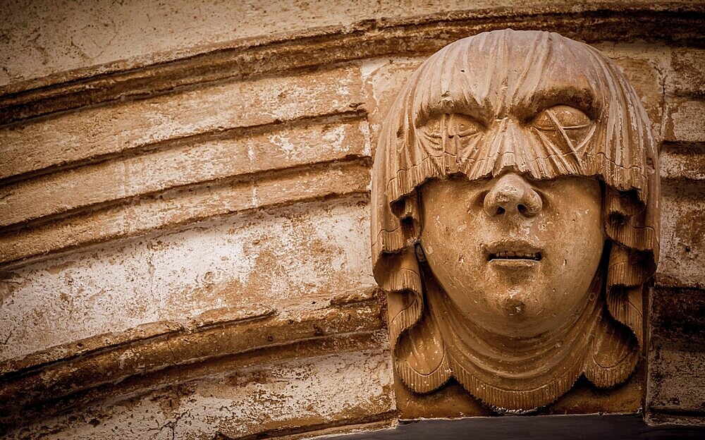 Gothic detail. Young woman portrait at the entrance of a 200 years old building in Ciutadella town, Menorca Spain