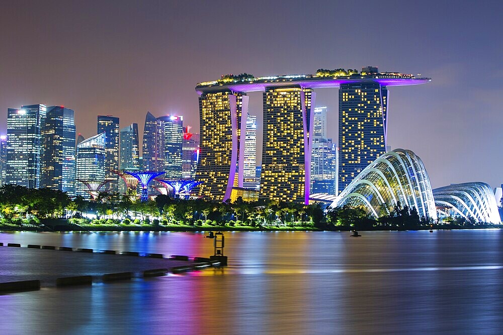 Marina Bay Sands and Gardens By The Bay with city skyline at dusk